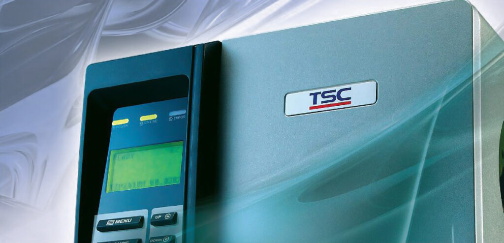 Primer plano de una Impresora Térmica TSC TTP-2410M que muestra su panel de control con pantalla y botones de operación, y el logotipo de TSC en la carcasa azul metálico.